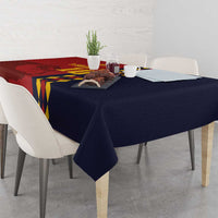 Red and navy tablecloth draped over table, Spain crest and diamond stripe graphics.
