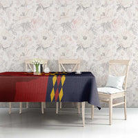 Red and navy Spain-themed tablecloth with crest and diamond pattern across table.