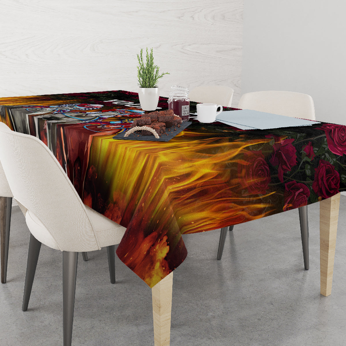Black flame-and-rose tablecloth covering dining table with chairs and decor