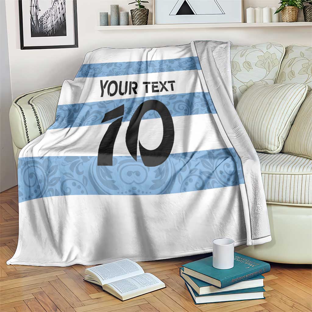 Argentina rugby blanket draped on sofa, blue-and-white stripes with large "10" and text