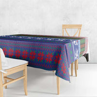 Blue plaid Christmas tablecloth with tartan and snowflake-style motifs on table edge