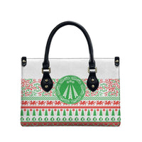 White tote bag with black top handles, green circular holiday emblem and red border