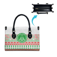 White tote bag with black zipper closure, green emblem on festive red-green panel
