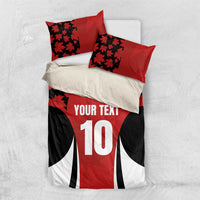 Flat-lay red and black bedding set with maple leaf pattern, number 10 and 'YOUR TEXT'.