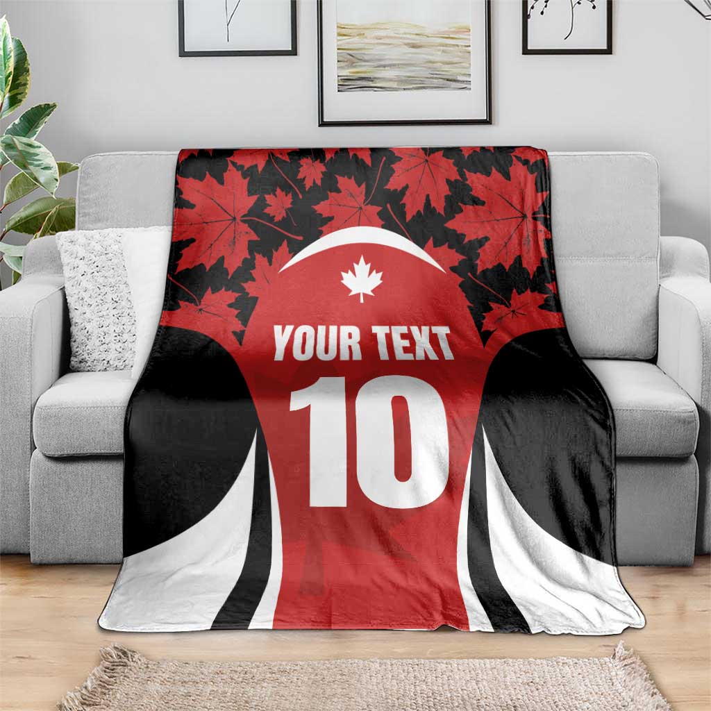 Red rugby jersey blanket on sofa, black and white curved side stripes, maple leaves, 10
