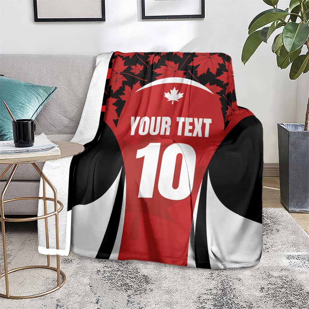 Red rugby jersey blanket on floor with plants, maple leaf design, black/white stripes, 10