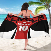Maple leaf sarong draped over back in red, black, and white with 'YOUR TEXT' 10 graphic