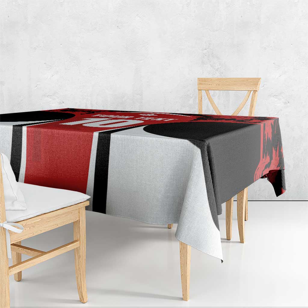 Red and black maple leaf tablecloth draped over table with white side panels