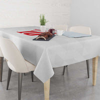 White tablecloth with red emblem across the center on a dining table