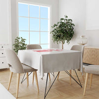 White tablecloth on dining table with red emblem at the center