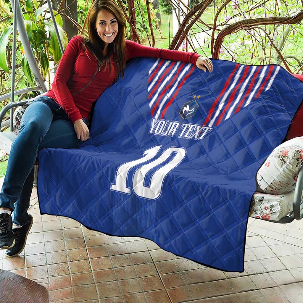 Blue quilt blanket held outdoors with red-and-white striped crest, shield emblem, “YOUR TEXT” and 10