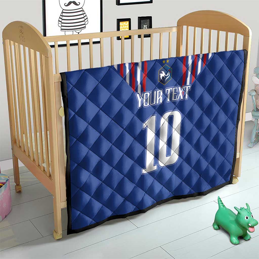 Blue quilt blanket in a crib with red-and-white striped crest, shield emblem, “YOUR TEXT” and 10