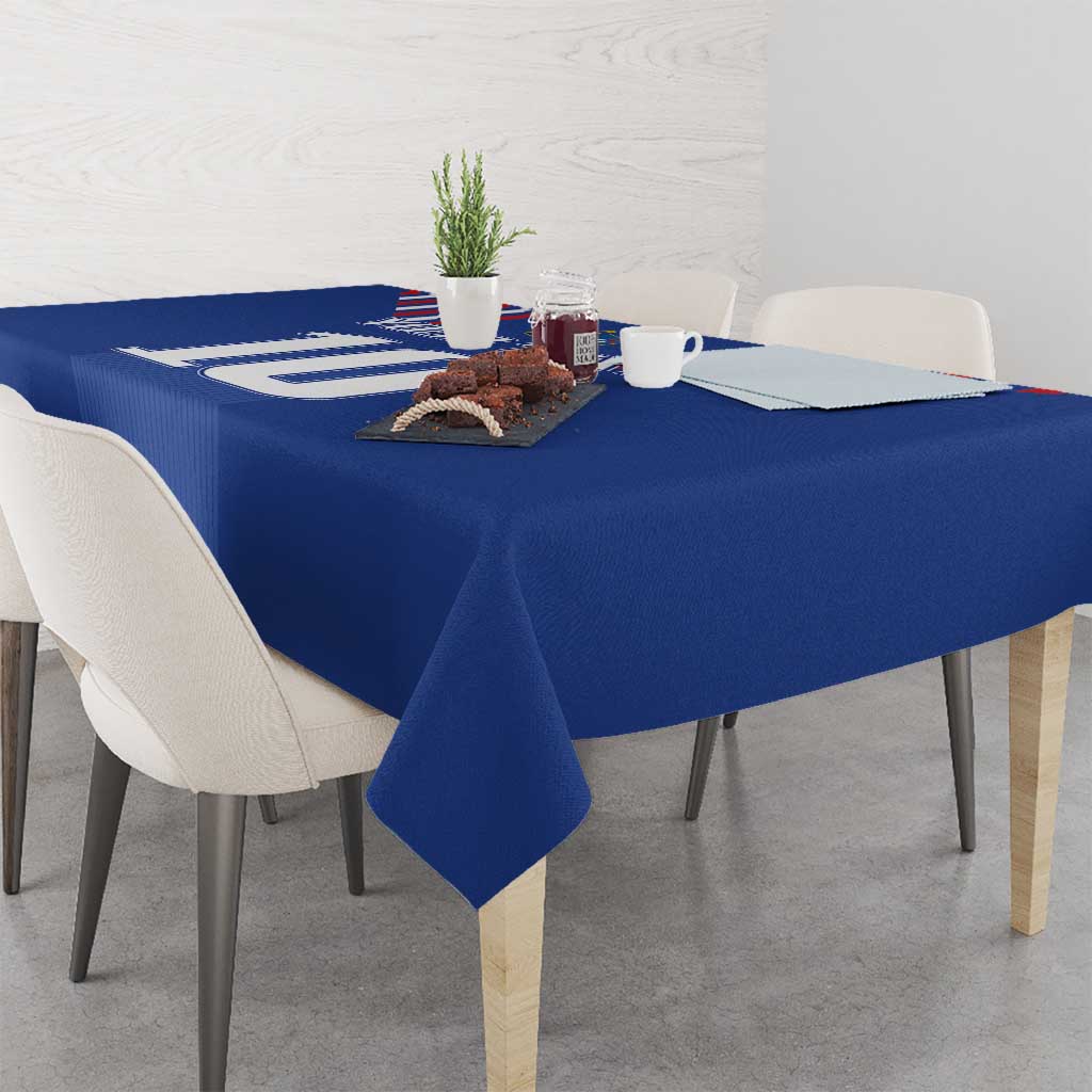 Blue soccer-themed tablecloth draped over rectangular dining table with chairs