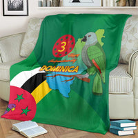 Green blanket showing Dominica flag diagonal stripes, map, and parrot bird graphic