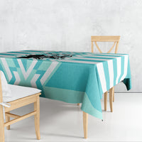 Teal and white geometric tablecloth draped over rectangular table