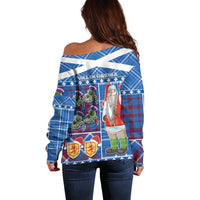 Blue off-shoulder tartan sweater, back view with Santa, flags, and thistle flowers