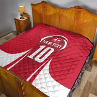 Red and white quilt blanket on bed with number 10 and custom text centered