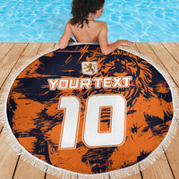 Orange round beach blanket with navy graphic, YOUR TEXT 10, crest, white tassel fringe