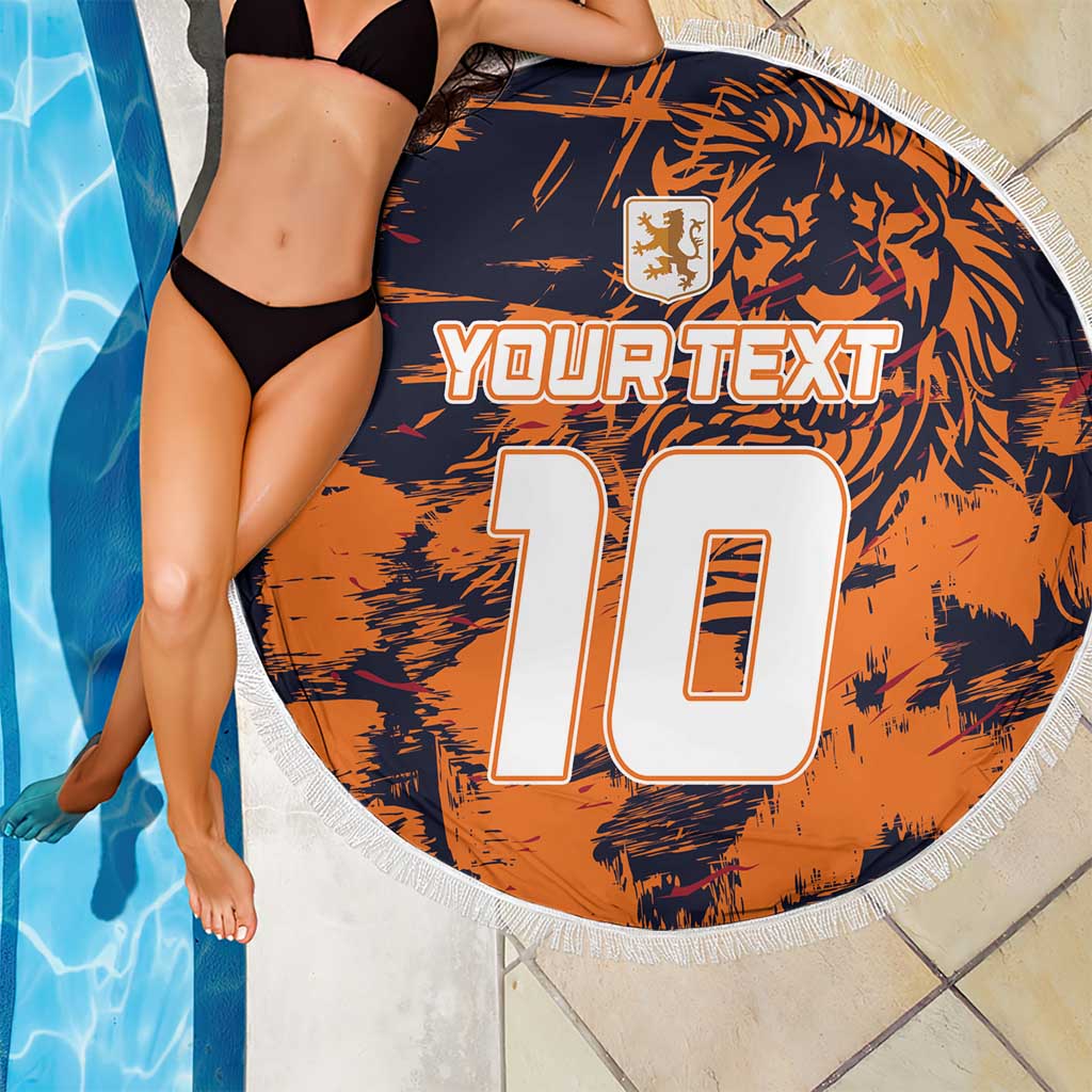 Orange round beach blanket with navy print, white fringe, YOUR TEXT 10, beside poolside model