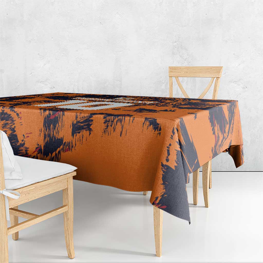 Orange and navy brush-pattern tablecloth with straight edge draped over table