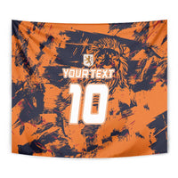 Close-up orange tapestry with dark splatter pattern, lion crest, YOURTEXT, and number 10