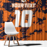 Close view of orange and navy window curtain fabric with jersey-number and lion print.