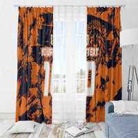 Orange and navy window curtains with jersey-number designs and lion graphic, draped on rod.