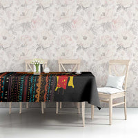 Black tribal-pattern tablecloth with colorful motifs across the tabletop