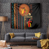 Black African tribal tapestry on brick wall with 'Happy Kwanzaa' and standing figure