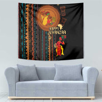 Black African tribal tapestry above gray sofa with 'Happy Kwanzaa' and candle motif