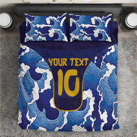 Blue duvet cover set with wave pattern, yellow 'YOUR TEXT' graphic, and two pillows