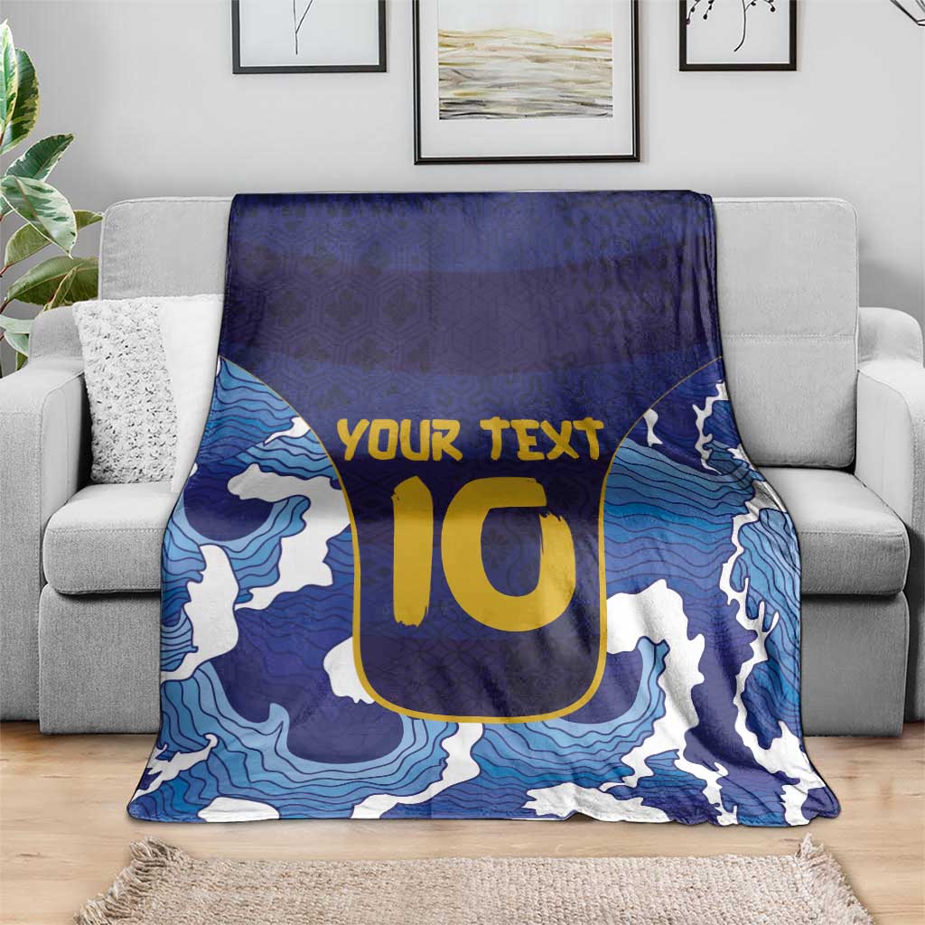 Blue wave-pattern rugby blanket with yellow U-style emblem and white accents, spread
