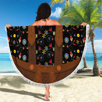 Round black beach blanket featuring brown lederhosen suspenders motif and multicolor flowers, fringe