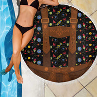 Round black beach blanket with brown lederhosen print, colorful flowers, white tassel fringe edge