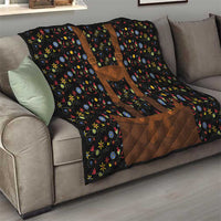 Black quilted blanket on sofa with brown applique and multicolor floral design