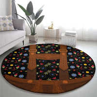 Round folk floral rug with black background, brown lederhosen apron motif and colorful flowers