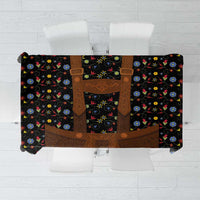 Black folk floral tablecloth with brown lederhosen-style centerpiece panel and colorful flowers