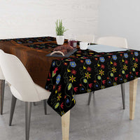 Black folk floral tablecloth draped on table with brown lederhosen-style center panel