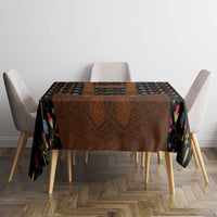 Black folk floral tablecloth covering dining table with brown lederhosen-style graphic center