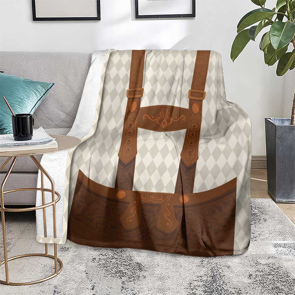 Beige diamond-pattern blanket with brown lederhosen print draped on a bed