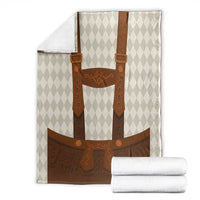 Beige and brown lederhosen-themed blanket with diamond background, shown with folded white