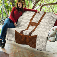 Outdoor view of white diamond quilt blanket with brown lederhosen motif