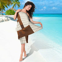 Beige diamond-pattern sarong wrap with brown leather-look bib detail