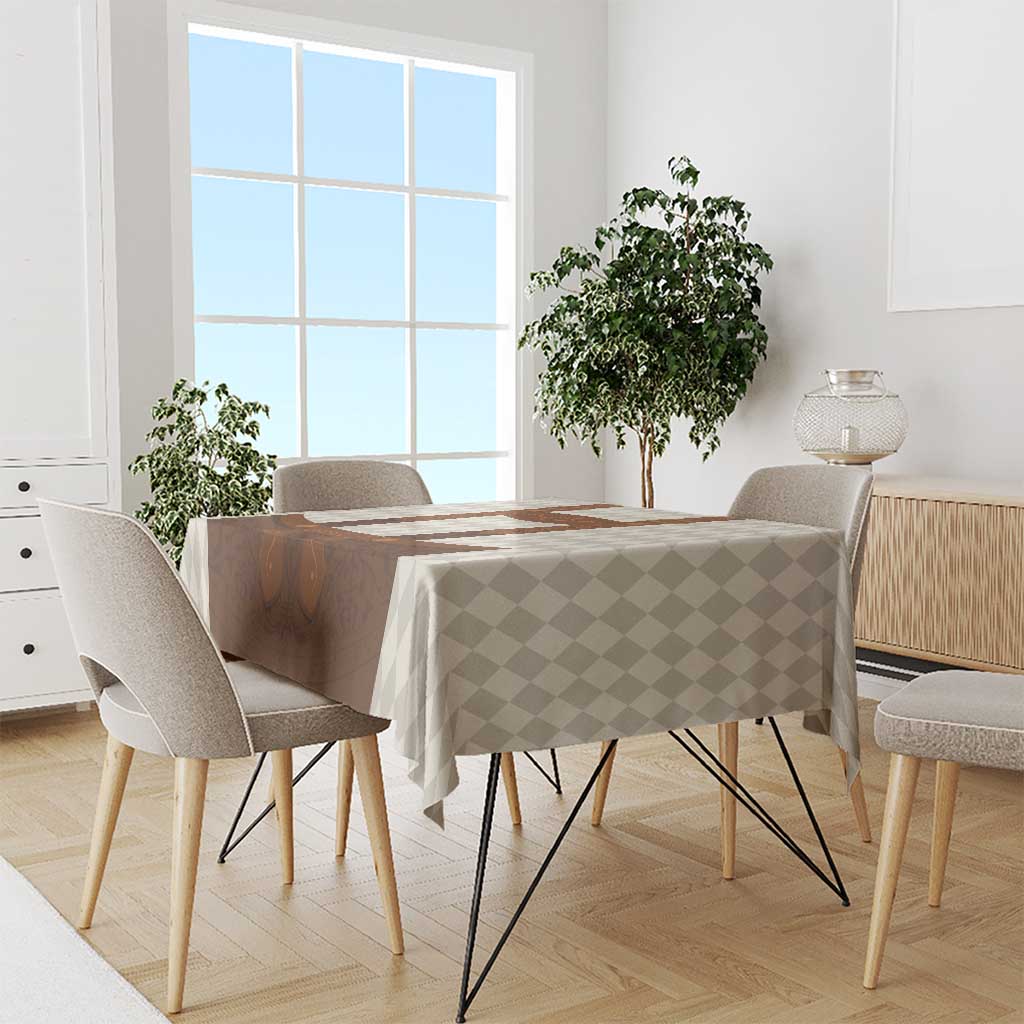 Beige check tablecloth with brown lederhosen graphic, draped on dining table