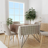 Beige check tablecloth with brown lederhosen graphic, draped on dining table