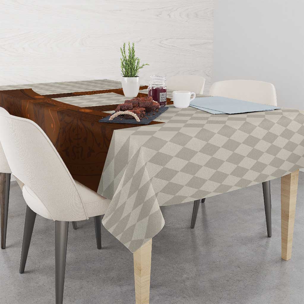 Brown lederhosen-themed tablecloth with beige diamond pattern on table