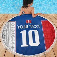 Round beach blanket on a pool deck, blue center with crest, large '10', and white fringe