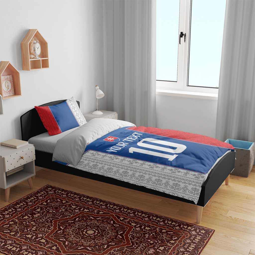 Blue and red bedding set on bed, featuring Slovakia crest and white number 10 with text