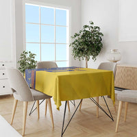 Yellow tablecloth with blue sports-style graphic on dining table with chairs