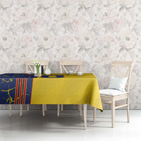 Yellow tablecloth with blue motif pattern covering dining table in light room